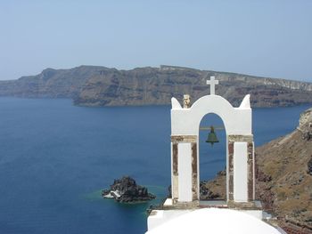 Built structure by sea against clear sky