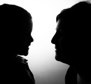 Close-up of silhouette mother and son against white background