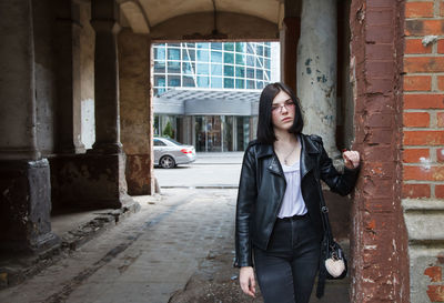 Full length of woman standing against building in city