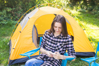 Young woman sitting at tent