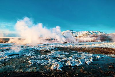 Hot spring against blue sky during winter