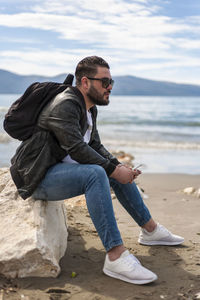 Man sitting on rock at beach