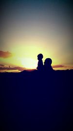 Silhouette men against sky during sunset