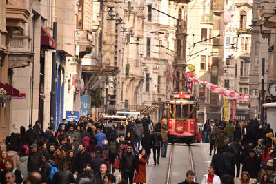 People walking on street amidst buildings in city