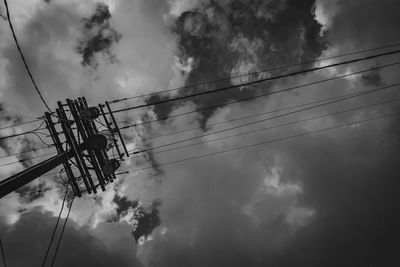 Low angle view of silhouette electricity pylon against sky