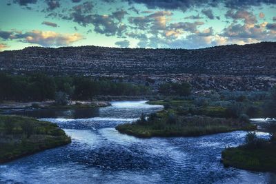 Scenic view of river against sky during sunset