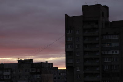 Low angle view of buildings against sky at sunset