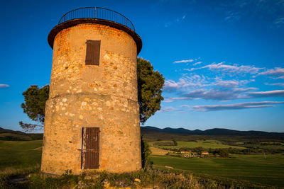 Built structure on landscape against blue sky