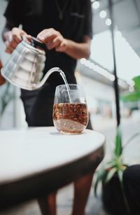 Man pouring coffee in cup on table