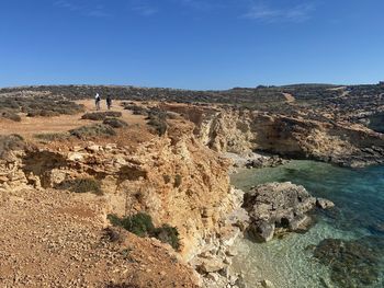 Scenic view of rocks against clear blue sky