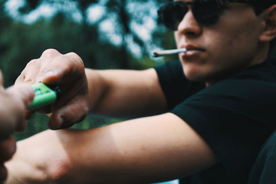 Midsection of man smoking cigarette