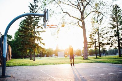 Man playing basket ball on field against sky