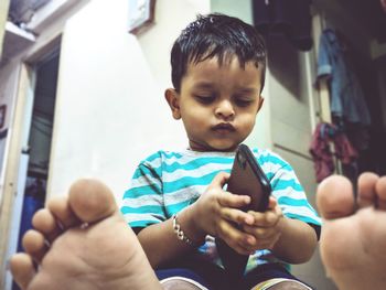 Rear view of boy using mobile phone