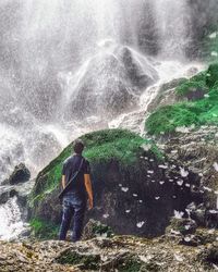 Man looking at waterfall