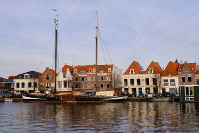 Sailing ship moored in haarlem on the spaarne in front of traditional dutch houses on hooimarkt.