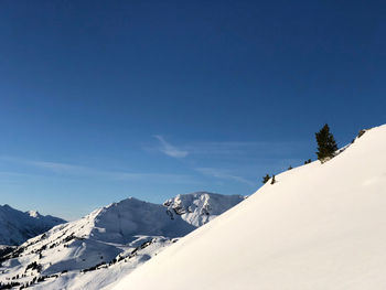 Scenic view of snowcapped mountains against clear blue sky