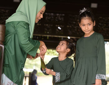 Smiling woman standing with kids at home