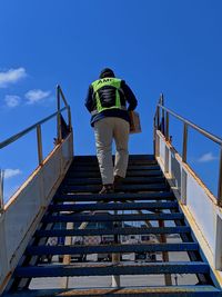 Low angle view of man on staircase against sky