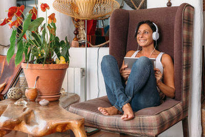 Young woman using phone while sitting on chair