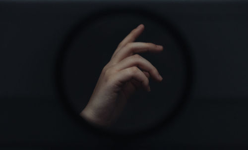 Close-up of human hand over black background