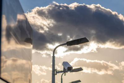 Low angle view of lighting equipment on street against sky