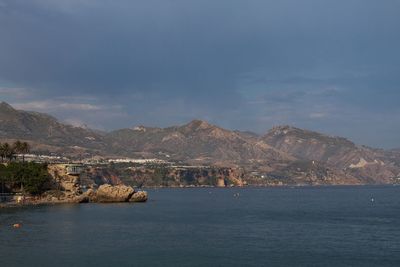 Scenic view of sea and mountains against sky