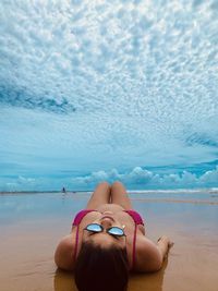 Rear view of woman lying on beach