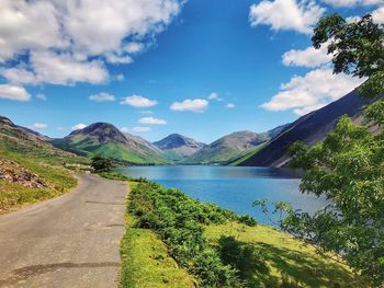 Scenic view of road by mountains against sky