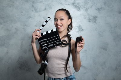 Close-up portrait of woman holding film slate