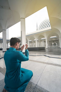 Rear view of man standing in mosque
