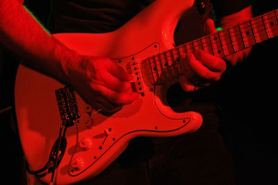 Midsection of man playing guitar