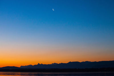 Scenic view of sea against clear sky at sunset