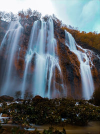 Scenic view of waterfall against sky