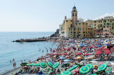 People at beach against clear sky