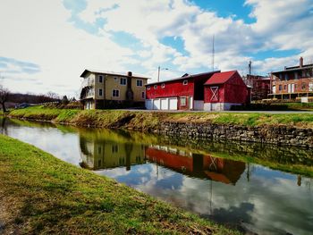 Houses by lake against sky