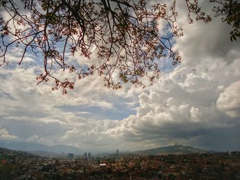 View of cityscape against cloudy sky