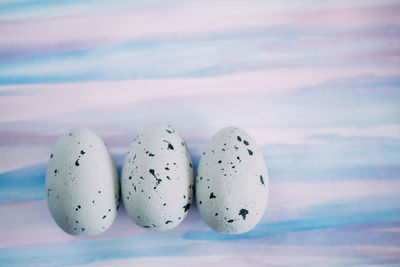 Close-up of quail eggs against colored background