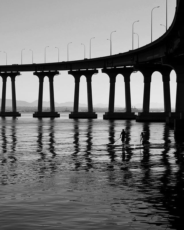 water, architecture, built structure, waterfront, reflection, bridge - man made structure, famous place, river, architectural column, travel destinations, clear sky, connection, travel, tourism, transportation, sky, international landmark, in a row, engineering, arch