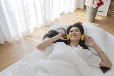 Young woman lying on bed at home