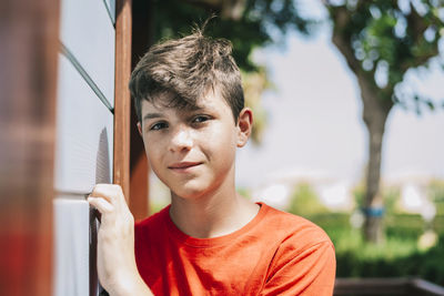 Portrait of teenage boy outside house