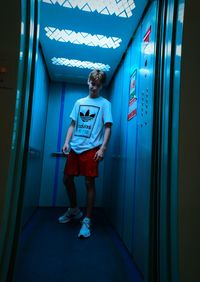 Full length of boy standing in corridor