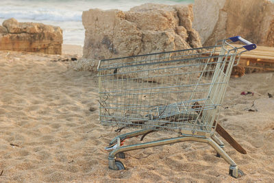 A supermarket trolley is on the beach