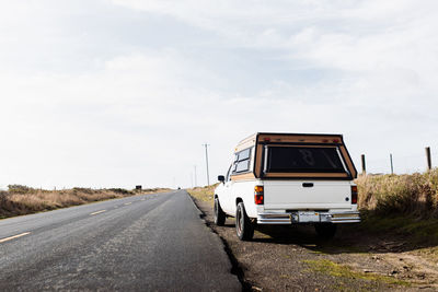 Modern automobile parked near asphalt road in countryside on sunny day in autumn