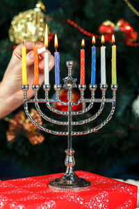 Cropped hand burning candles on menorah