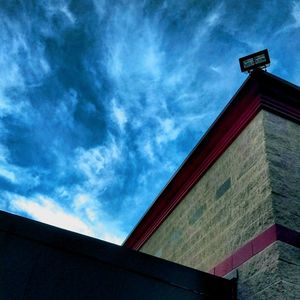 Low angle view of building against cloudy sky