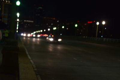 Cars on illuminated city street at night