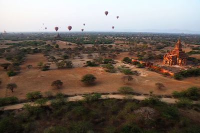 Hot air balloon flying over bagan archaeological zone against sky during sunset