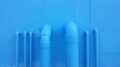 Close-up of blue pipes against wall