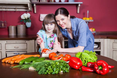 Girl and vegetables on table at home