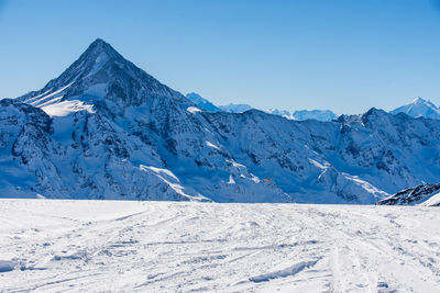 Scenic view of snowcapped mountains against clear blue sky